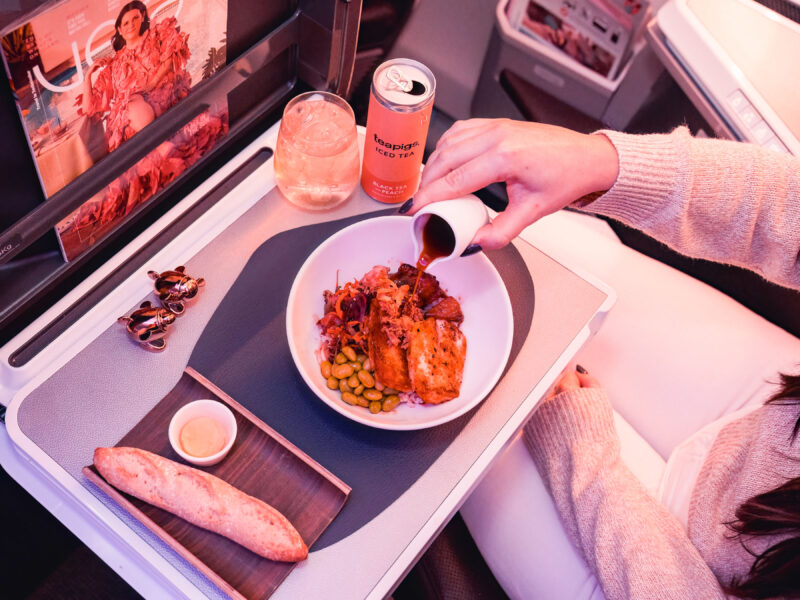 a person pouring a drink into a bowl of food