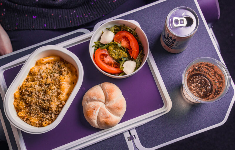 food on a tray with a drink and a can of soda