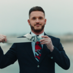 a man in a suit holding a belt