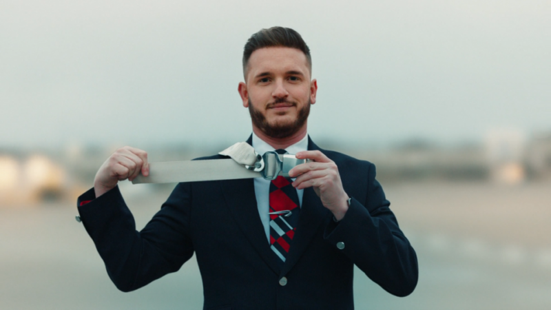 a man in a suit holding a belt