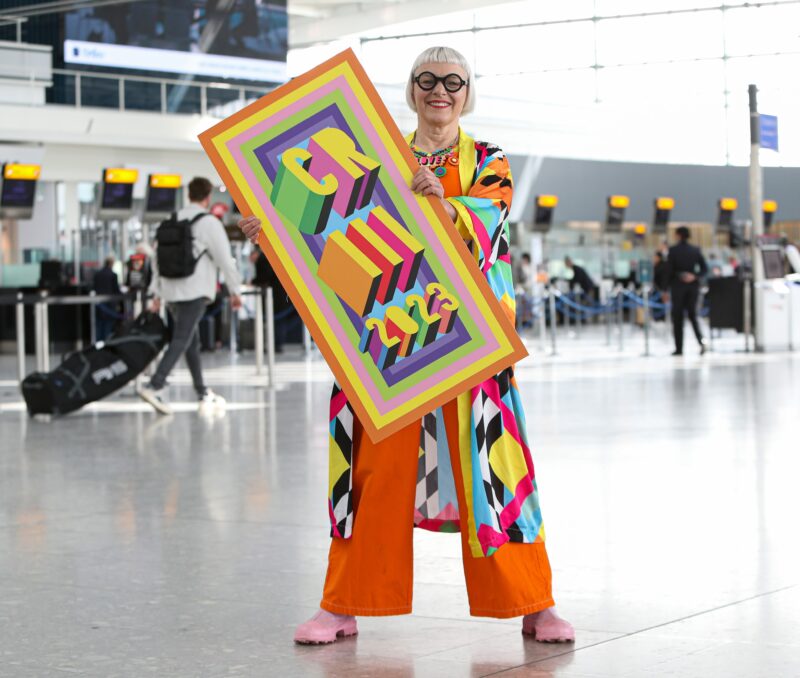 a woman holding a large sign in an airport