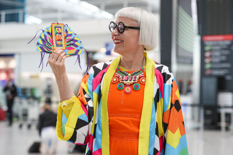 a woman holding a colorful fan