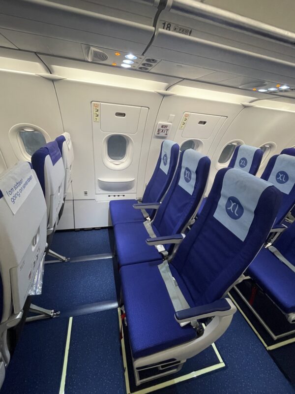a row of blue chairs in an airplane