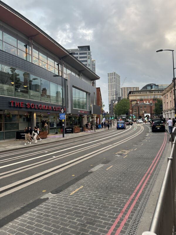 a street with buildings and people walking on it