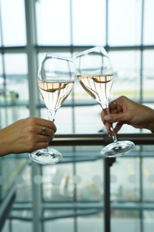 a pair of hands holding wine glasses