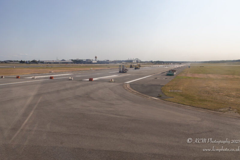an airport runway with a few vehicles on it