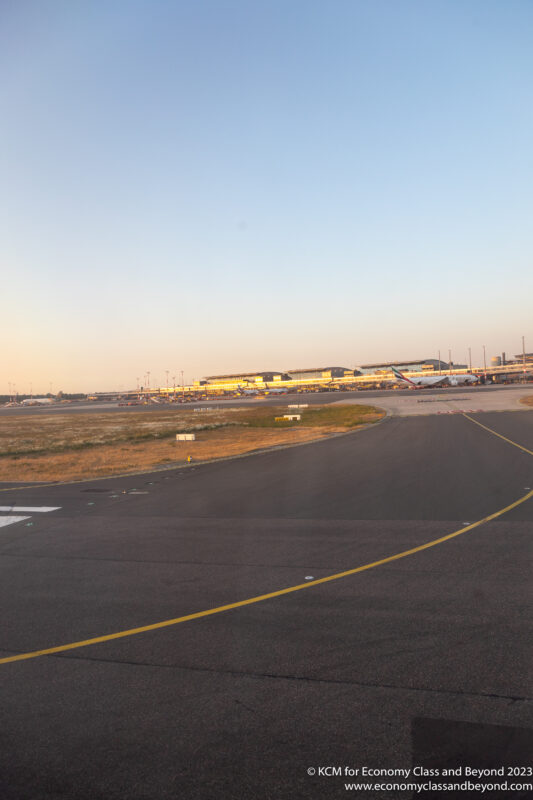 an airport runway with an airplane in the distance
