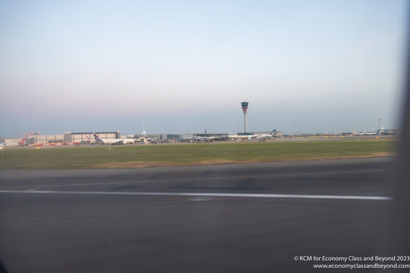 a runway with a tower and buildings in the background