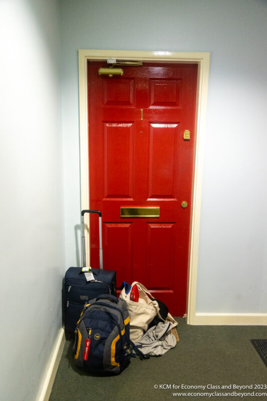 a red door with luggage on the floor