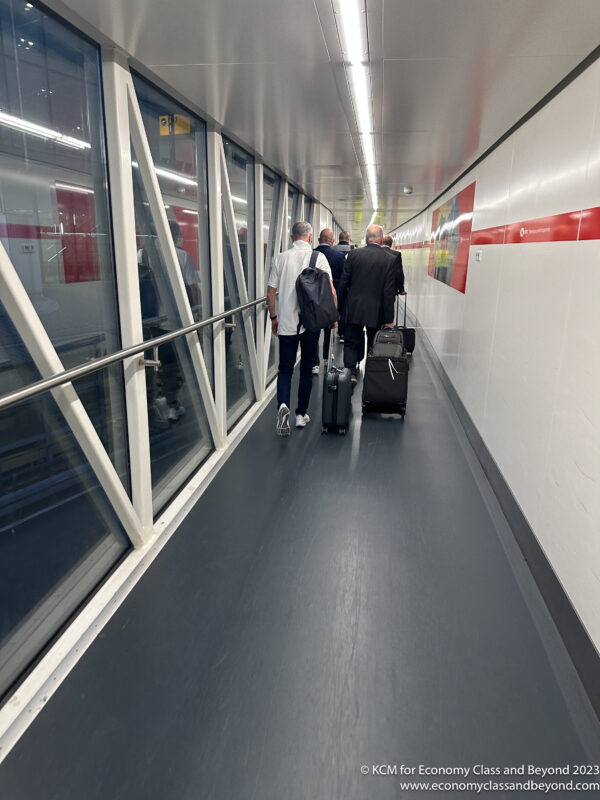 a group of people with luggage walking down a hallway