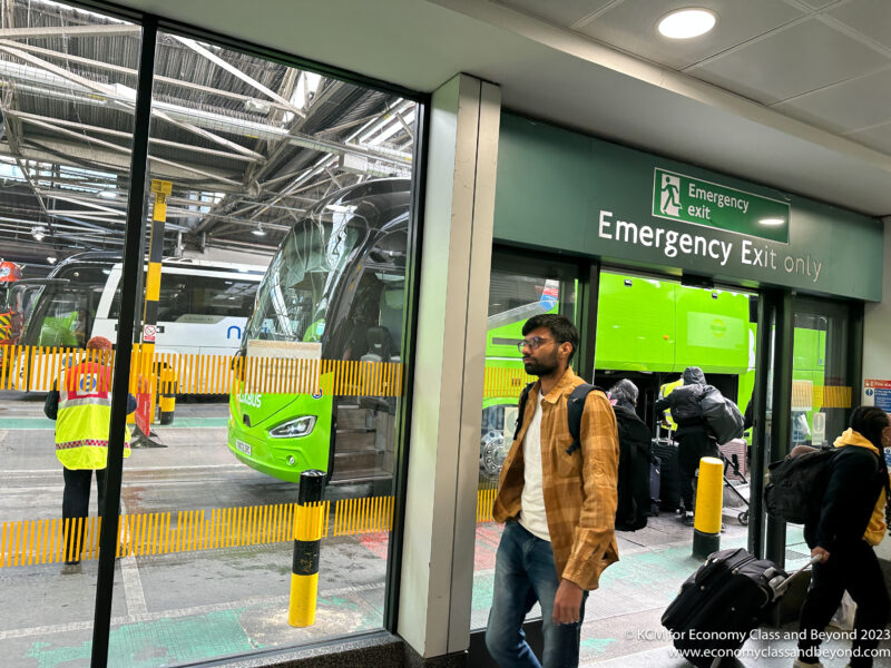 a man walking in a building with a green bus