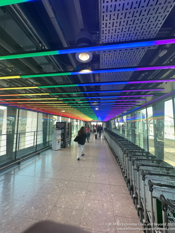 a group of people walking in a hallway with colorful lights