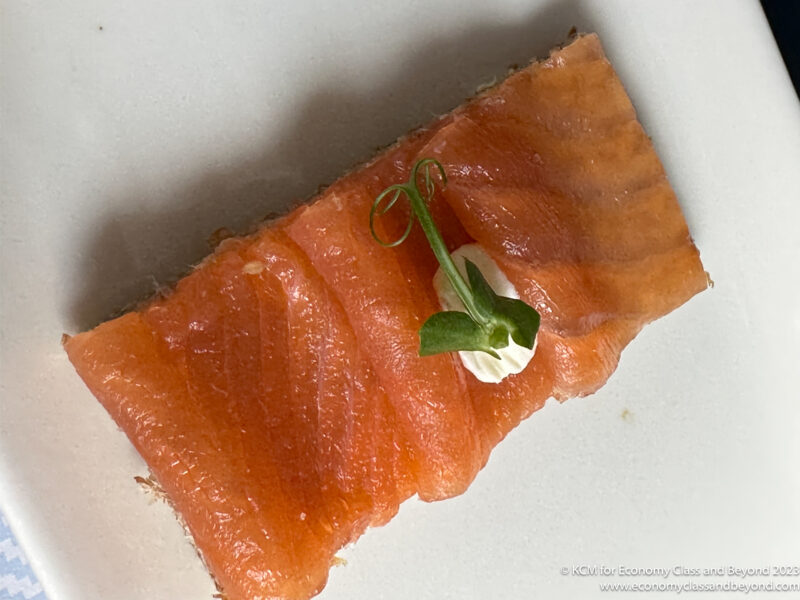 a piece of salmon with a green sprig of herb on top