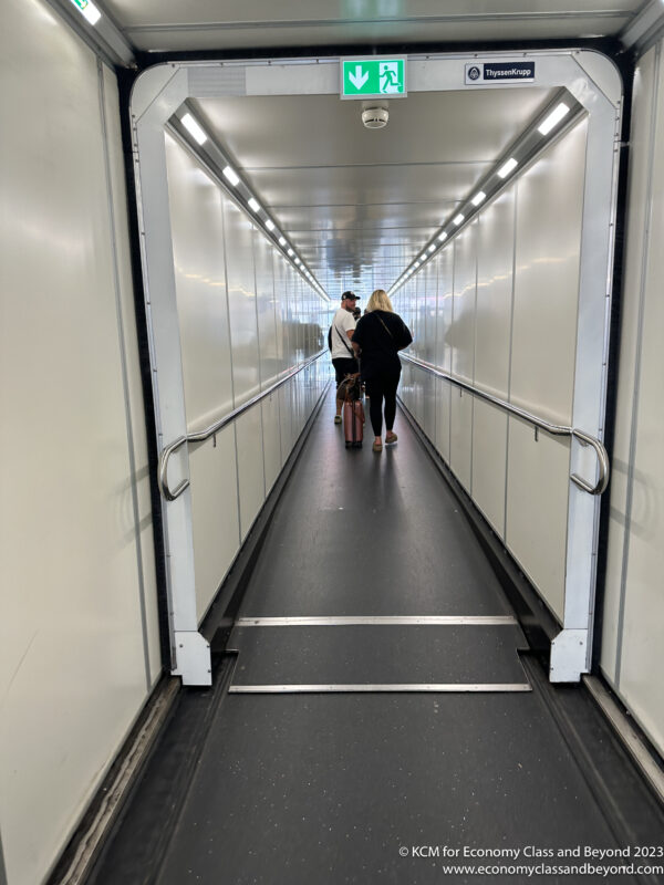 a man and woman walking down a long hallway