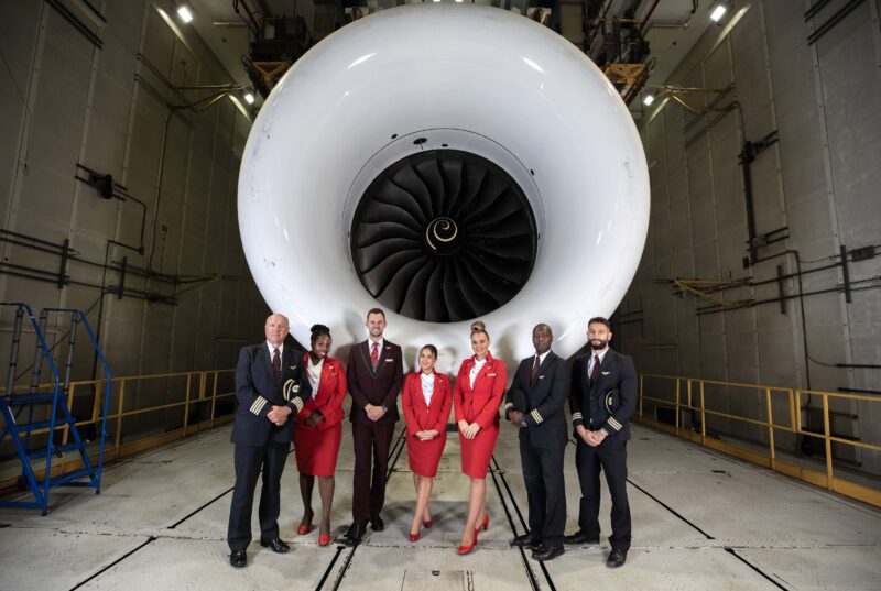 a group of people standing in front of a jet engine