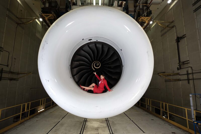 a woman in a red dress sitting in a large white jet engine