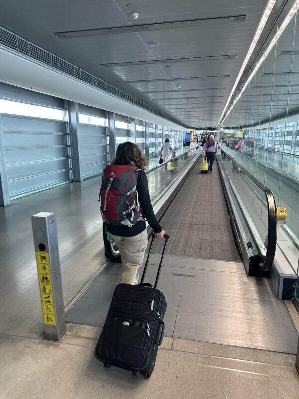 a woman pulling luggage down an escalator