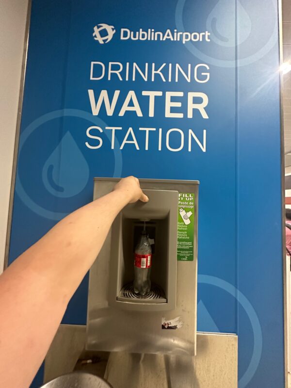 a hand pushing a water dispenser