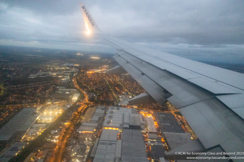 an airplane wing and city lights