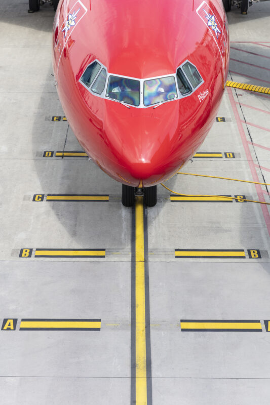 a red airplane on a runway