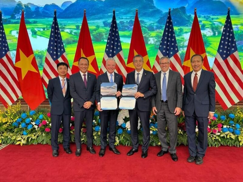 a group of men in suits standing in front of flags