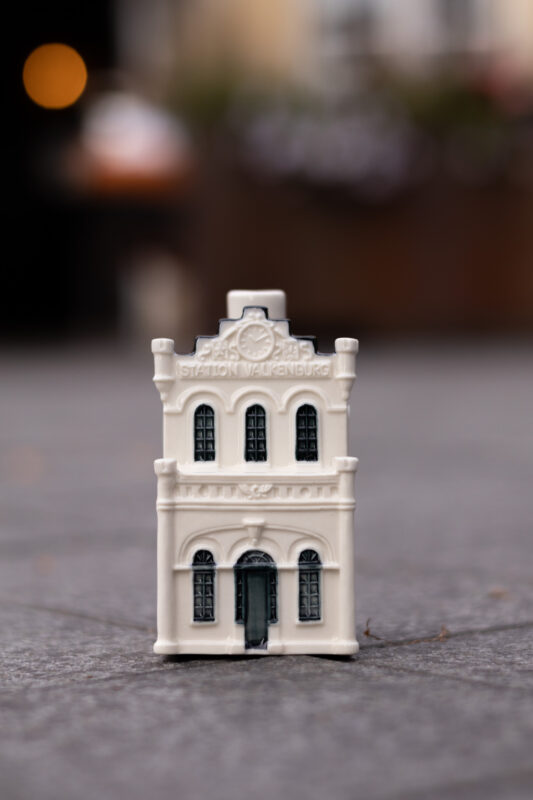 a small white building on a grey surface
