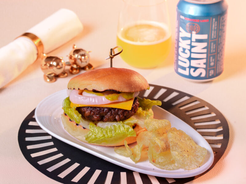 a burger on a plate next to a drink