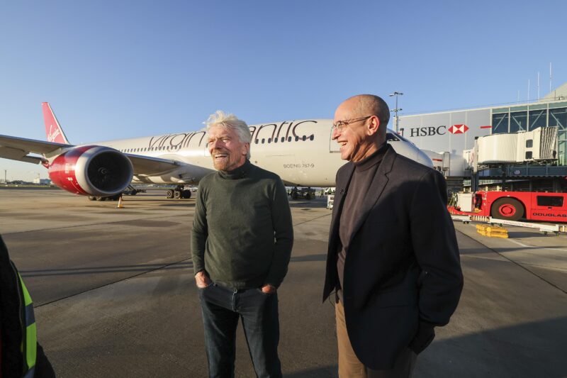 two men standing next to an airplane