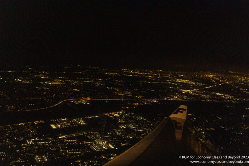 an airplane wing over a city at night