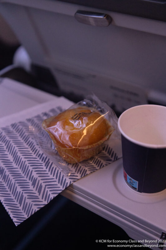 a cup of coffee and a pastry on a tray