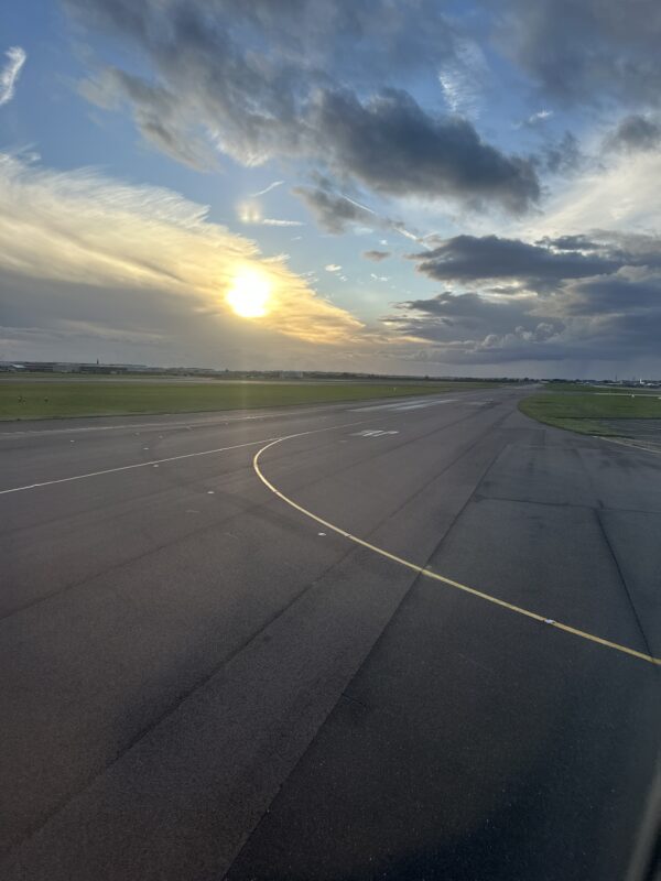a runway with a sun setting