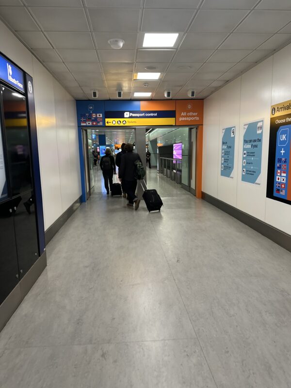 people walking in a hallway with luggage