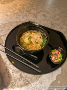 a bowl of soup with chopsticks and a bowl of soup on a tray