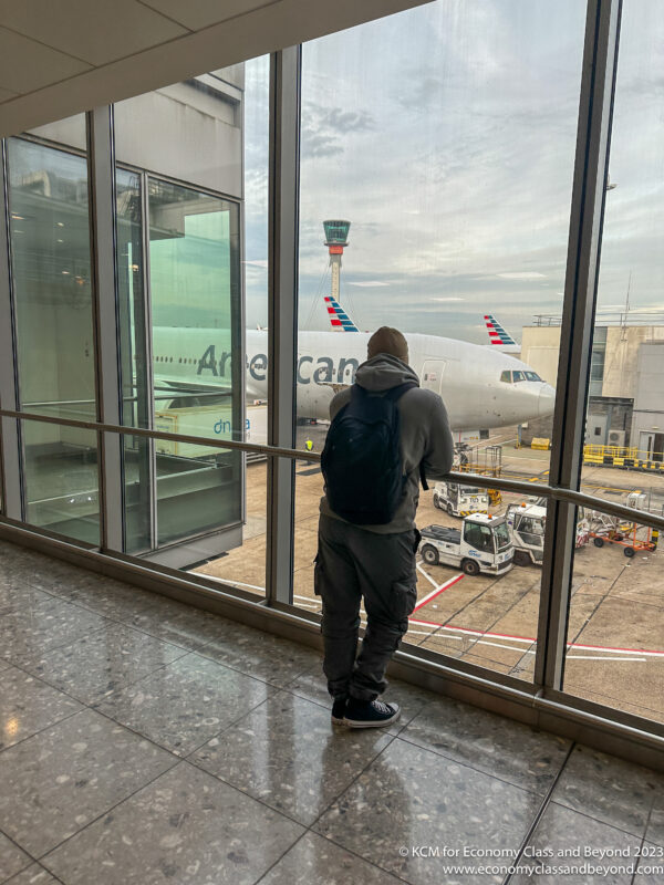 a man looking out a window at an airplane