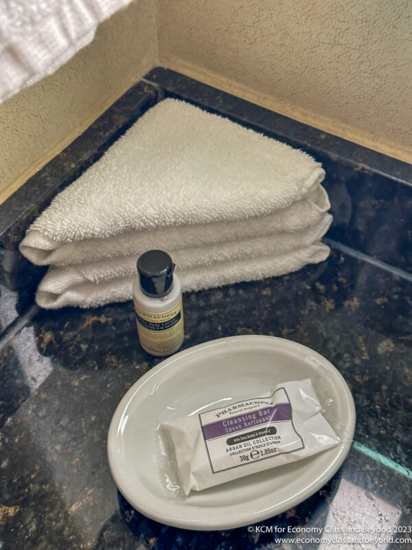 a white plate with a small bottle of cleaning gel and a stack of towels