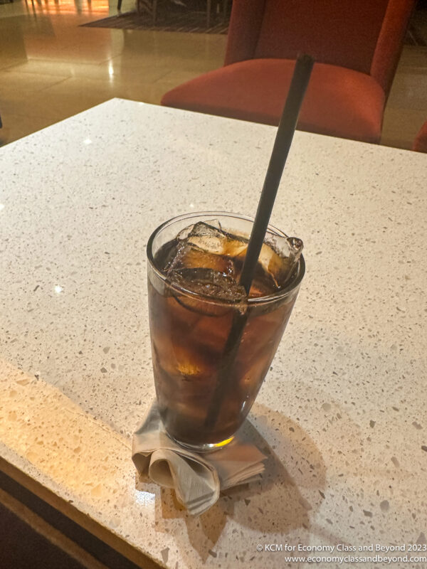 a glass with ice and a straw on a table