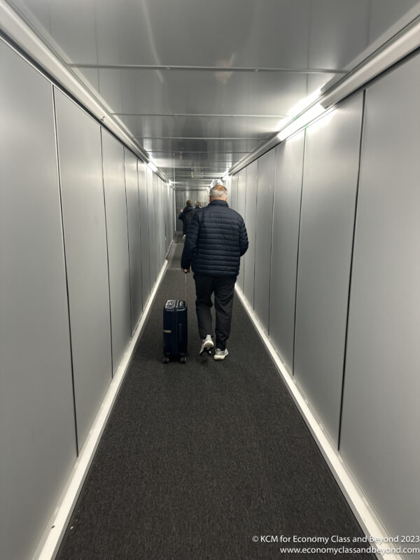a man walking down a hallway with a luggage