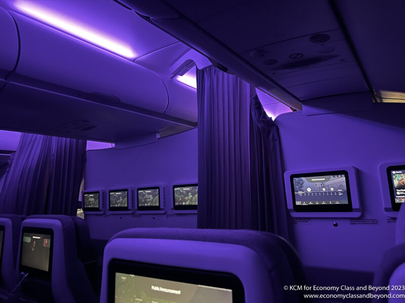 a purple room with a row of screens and a purple curtain