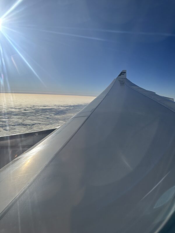 wing of an airplane flying over clouds