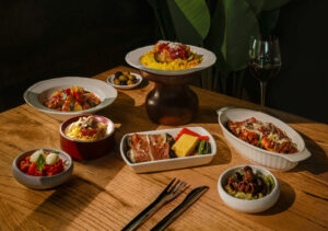 a table with plates of food and a glass of wine