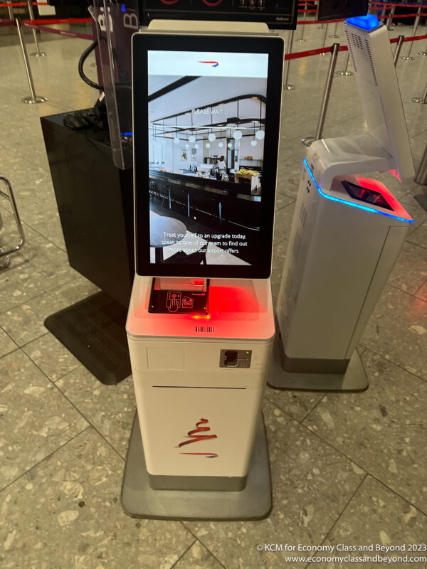 a white electronic kiosk with a screen on it