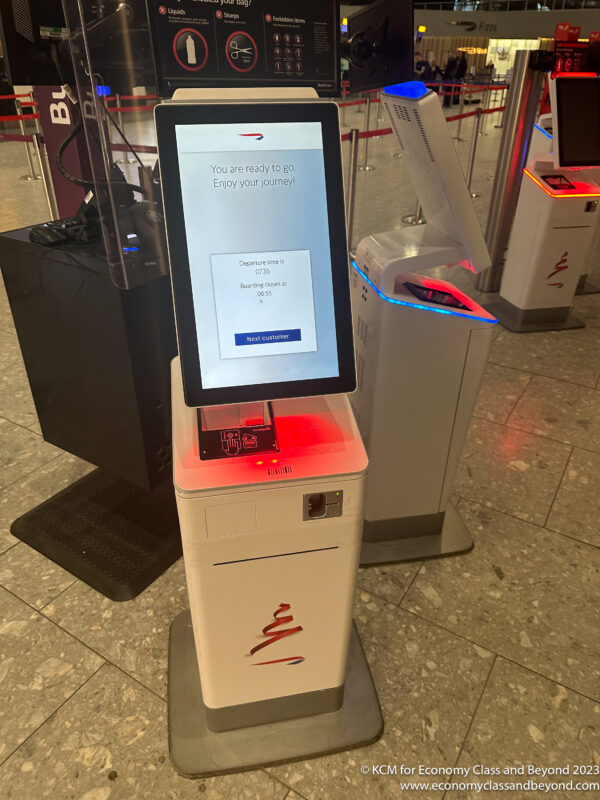 a white electronic kiosk with a screen on it