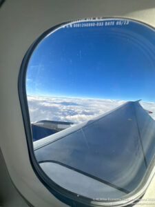 an airplane wing and clouds seen through a window