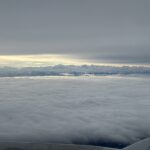 a view of clouds and mountains from an airplane