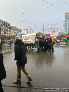 a group of people standing in a street with a wagon