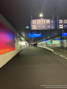 a walkway with signs and people walking