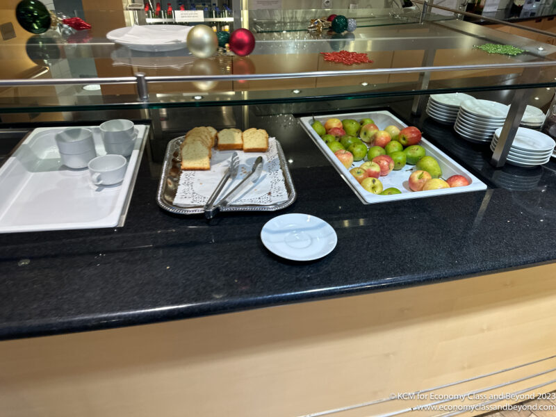 a buffet with plates of bread and apples