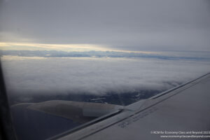 a view of the wing of an airplane above the clouds