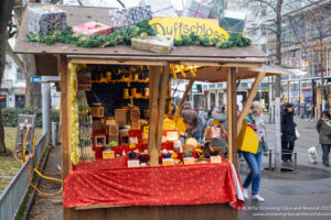 a small wooden booth with a red cloth and a sign with a group of people walking