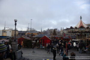 a crowd of people in a square with red tents and lights